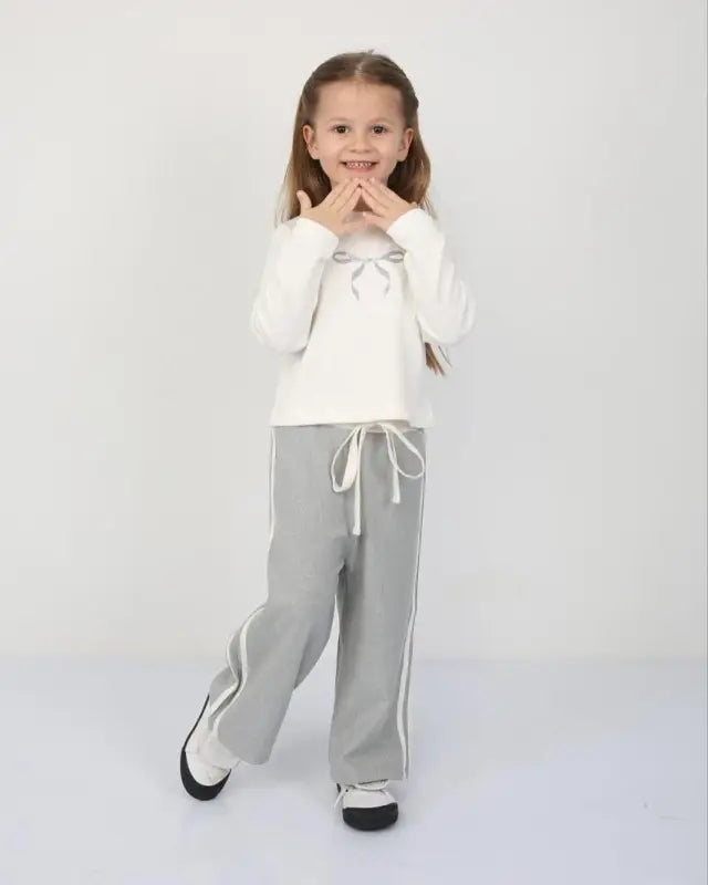 Beyaz Fiyonklu Kız Çocuk Eşofman Takımı – Uzun Kollu Üst & Gri Bol Paça Pantolon | 5-7 Yaş Günlük Konfor” - Kız Çocuk
